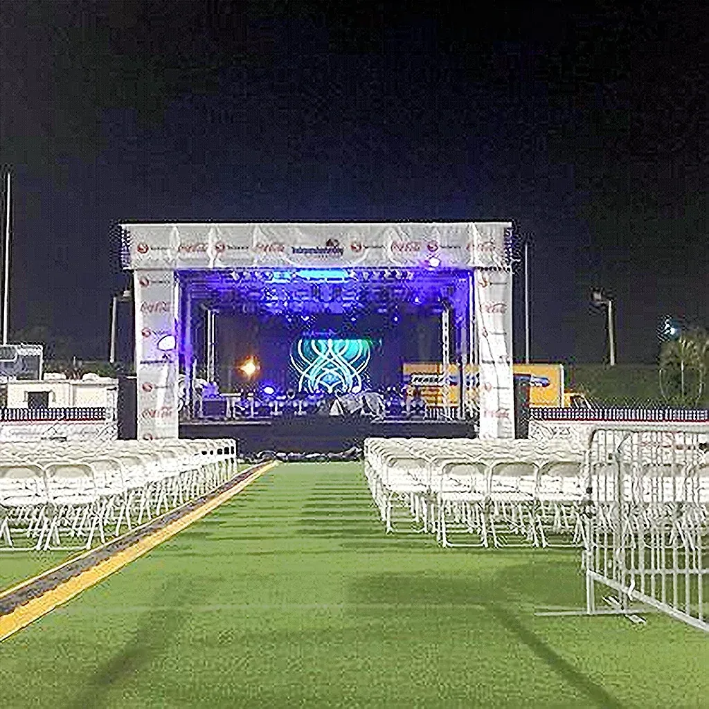 APEX 3224 stage lit in purple at an evening event with rows of seating